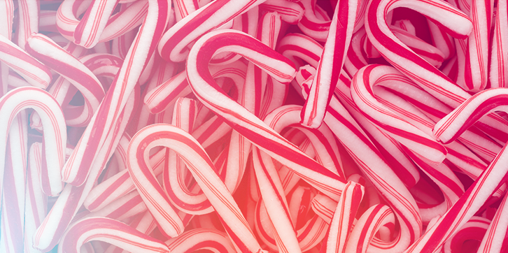 Photo of red and white candy canes piled so high you cannot see the surface below. A Family Christmas is a sweet and exciting experience for children.